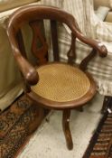 An oak captain style office chair with caned seat