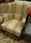 An early to mid 20th Century upholstered wingback scroll armchair in the George III taste,