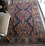 An Afghan triple medallion rug with brocade ends,