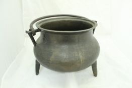 An 18th Century bronze cauldron of baluster form with iron swing handle
