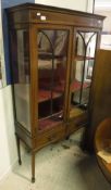 An Edwardian mahogany and inlaid two door display cabinet with two drawers on square tapered legs