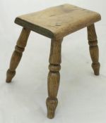 A 19th Century elm milking stool together with a cast metal painted stick stand containing various