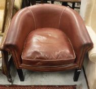 A modern tub chair with red leather upholstery,