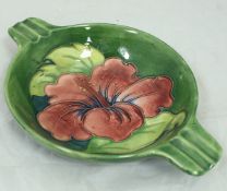 A Moorcroft green ground ashtray with floral decoration,