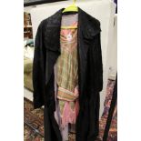 An early 20th Century black silk opera cape with roundel puff decoration and lilac lining bearing