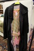 An early 20th Century black silk opera cape with roundel puff decoration and lilac lining bearing