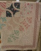 A mid 20th Century quilt in pink and red hues