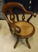 An oak captain style office chair with caned seat