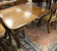 A Victorian mahogany extending dining table with turned and reeded supports to brown china castors