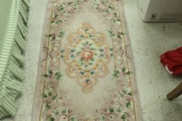 A Chinese superwash rug, the central panel set with floral decorated medallion on a lilac ground,