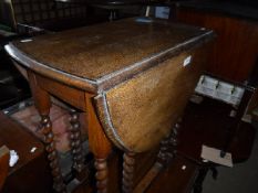 A 1930's oak oval gate-leg dining table,