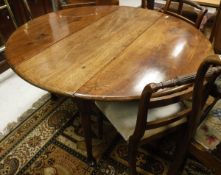 A late George II mahogany oval drop leaf dining table on turned tapering legs to pad feet together