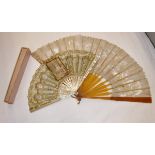 A 19th century mother of pearl stick fan with printed decoration depicting a lady in a boudoir