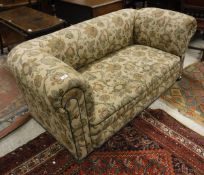 A Victorian drop end sofa with cream ground and floral patterned upholstery to bun feet