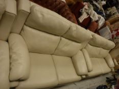 A large cream leather two seater sofa together with a matching smaller cream leather sofa and a