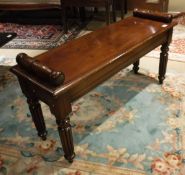 A mahogany window seat in the Victorian manner with tapered reeded legs