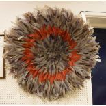A 20th century Ju Ju (West African) feathered headdress of circular form in purple and red feathers