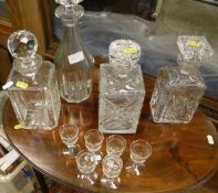 A collection of four various cut glass decanters and stoppers,