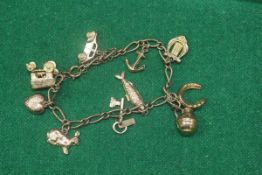 A 9 carat gold charm bracelet together with ten various charms (14 g over all)