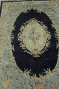 A Chinese silk rug, the central panel set with floral decorated medallion on a blue ground,