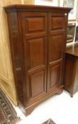 A mahogany two door cupboard with fielded panel doors enclosing adjustable shelving to bracket foot