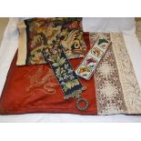 A 19th Century table cover with dragon decoration and crochet work panels on an oxblood red silk