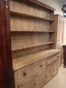 A Victorian pine farmhouse kitchen dresser with boarded three tier plate rack over two drawers and