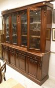 A Victorian style mahogany book case cabinet with two pairs of cabinet doors over four drawers and