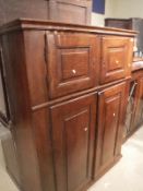 An oak cupboard with two pairs of fielded panelled doors