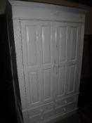 A modern painted pine two door wardrobe with three drawers