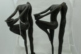 A pair of modern bronzed figural candlesticks in the Art Deco taste as long-haired nudes holding a