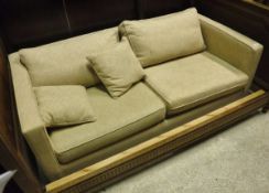 A modern cream upholstered two seat sofa bed