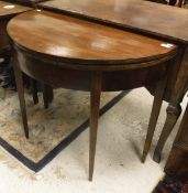 A Regency mahogany and cross-banded fold over card table of demi-lune form