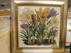 A set of three floral needleworks all framed and glazed,