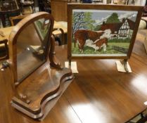 A dressing mirror together with an oak fire screen with needlework decoration behind a glazed front