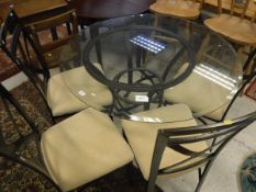 A circular glass top table with metal base together with four matching metal chairs with cream