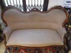 A Victorian walnut framed sofa with cream, green and red diamond shape patterned upholstery,