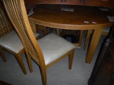 A circular oak breakfast table on square supports by John Burris,