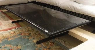 A metal framed glass-topped coffee table