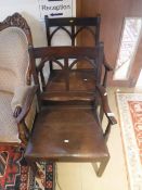 A pair of 19th Century oak elbow chairs the bar backs with gothic arch decoration over open arms on