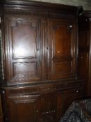 A 19th Century Continental oak cupboard with moulded cornice over two fielded panelled doors,