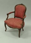 A pair of walnut framed open arm elbow chairs in the Louis XIV taste,