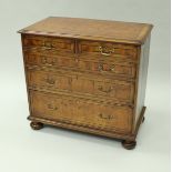 An oyster veneered chest of drawers,