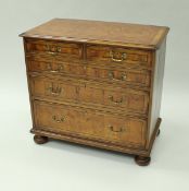 An oyster veneered chest of drawers,