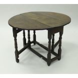 An 18th Century oak oval gate-leg drop-leaf dining table of small proportions,