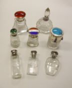 A collection of eight silver and enamel mounted scent bottles with clear glass bodies