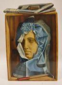 J P "Stone bust wrapped in newspaper in a wooden box with hammer in foreground",