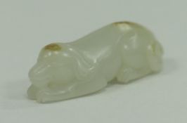 A Chinese carved jade figure of a recumbent dog,