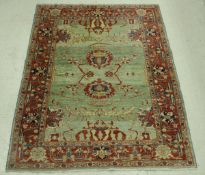 A Ziegler design carpet, the central panel with floral decoration on a pale green ground,