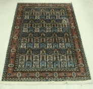 An Eastern carpet, the central panel set with repeating floral decorated tile design,